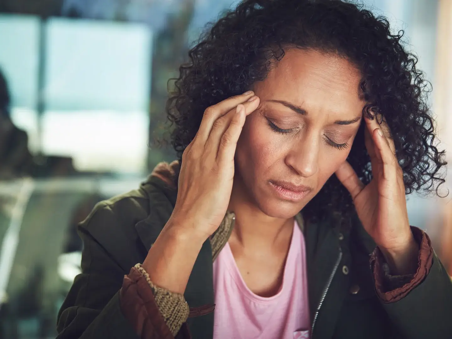 An adult holding their temples during a headache