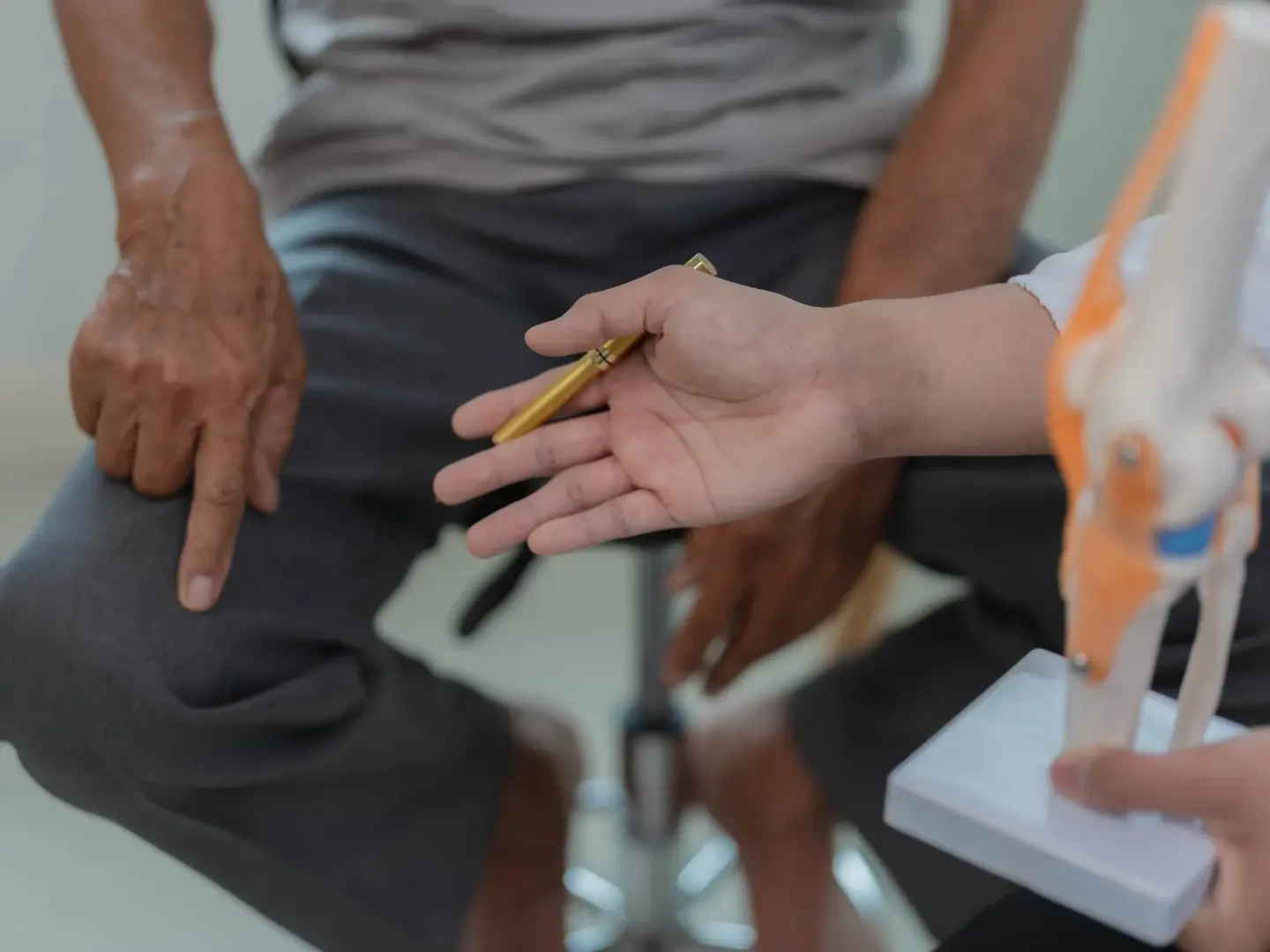 A patient discussing knee discomfort with a clinician