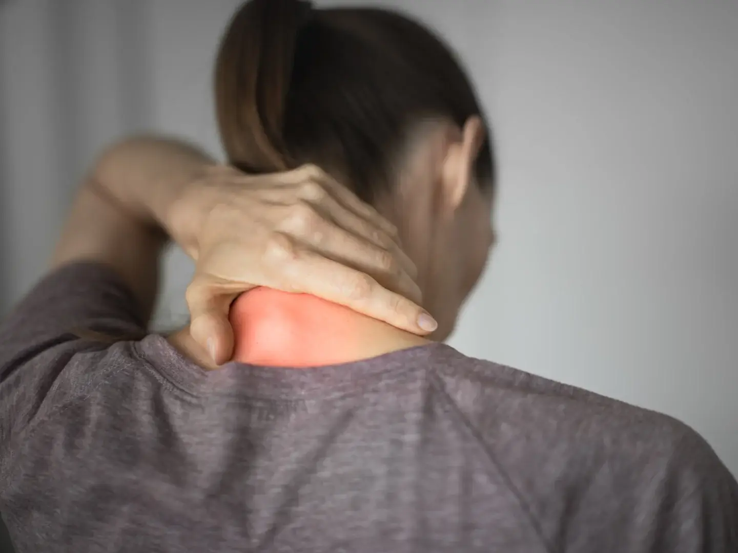 An adult holding the back of their neck