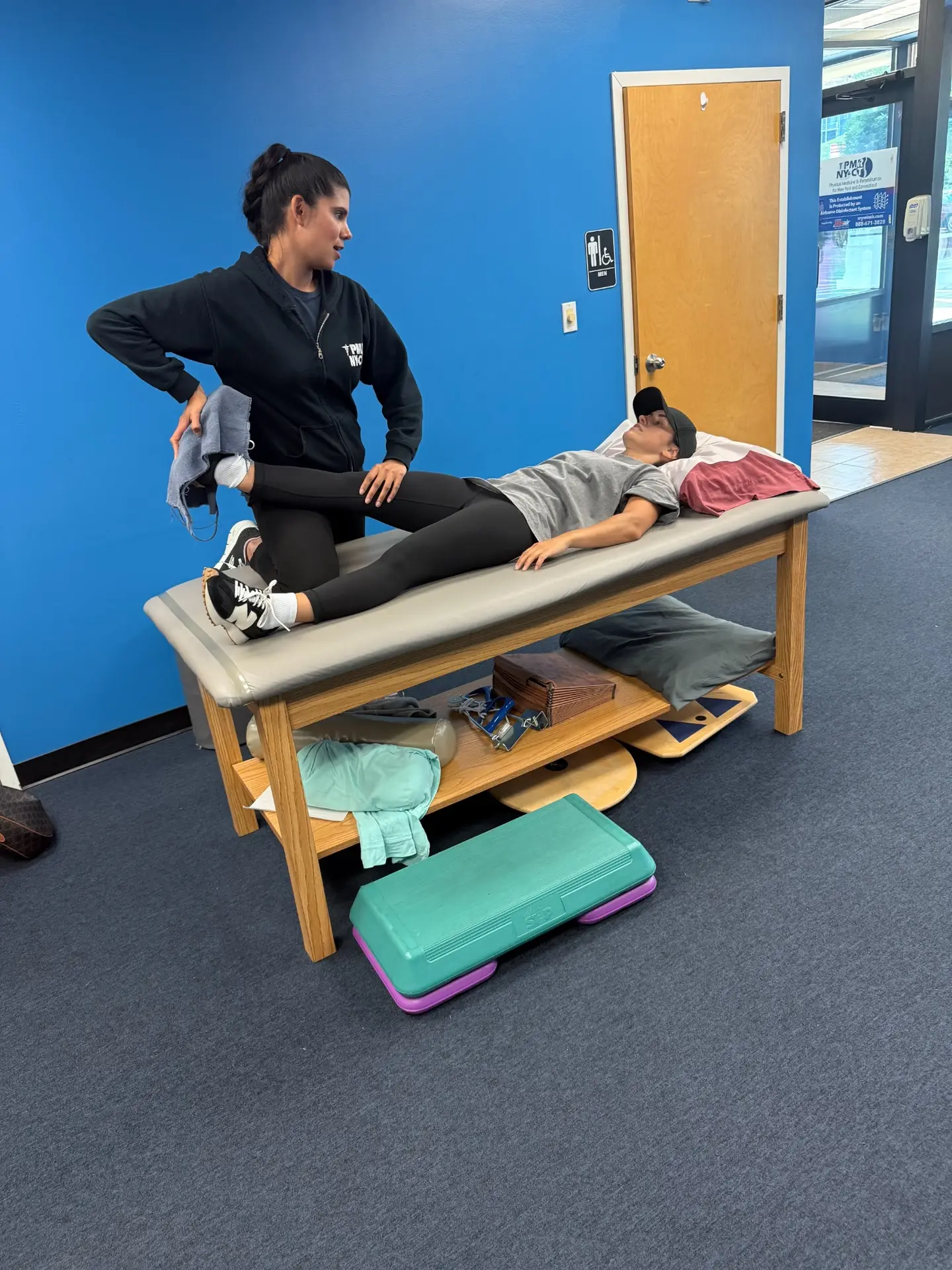 A PMR physical therapist helping a patient with a leg stretch