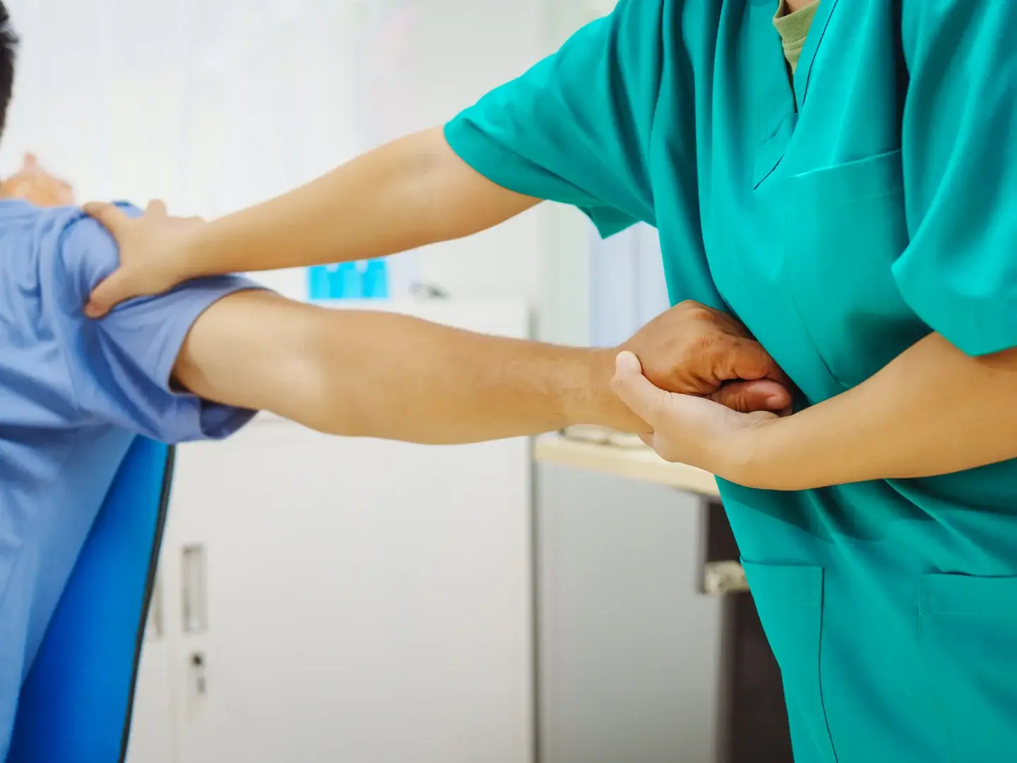 A clinician assisting a patient with shoulder movement