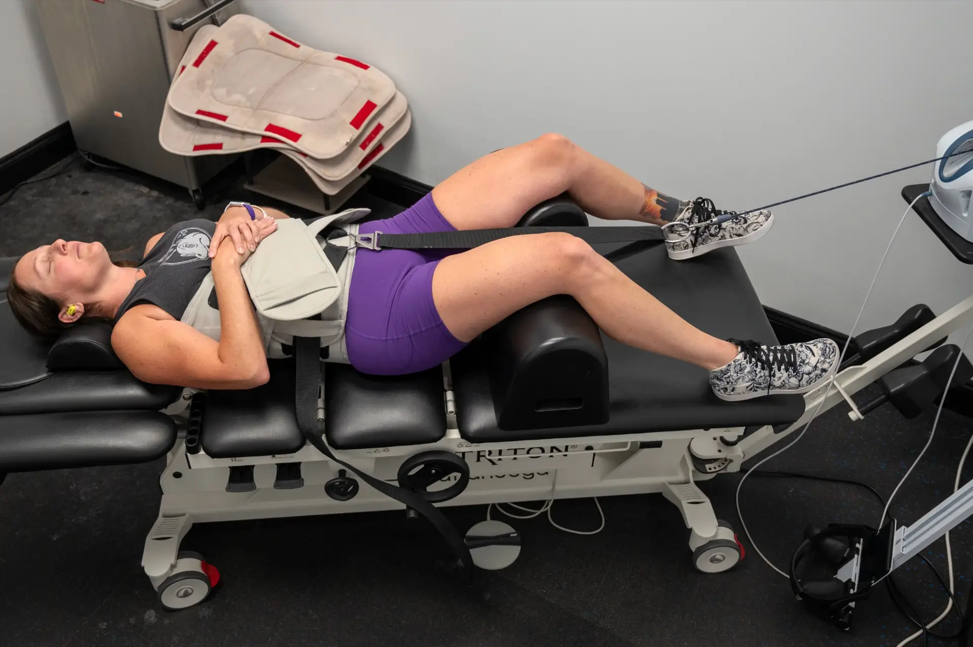 A patient receiving spinal decompression on a traction table at PMR